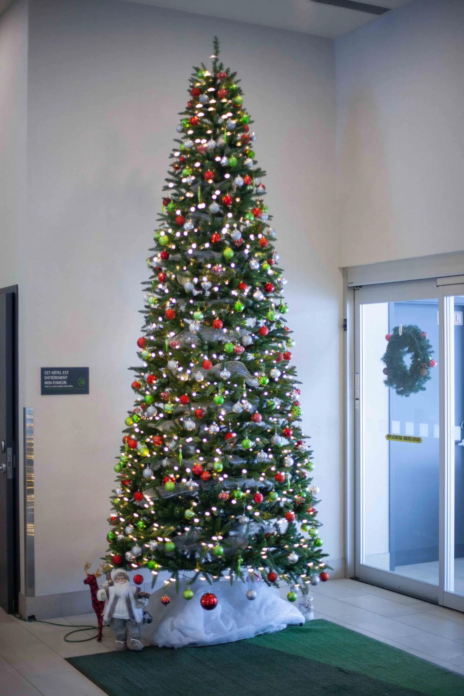 Sapin de Noël décoré de rouge et de vert dans le hall d’une concession automobile