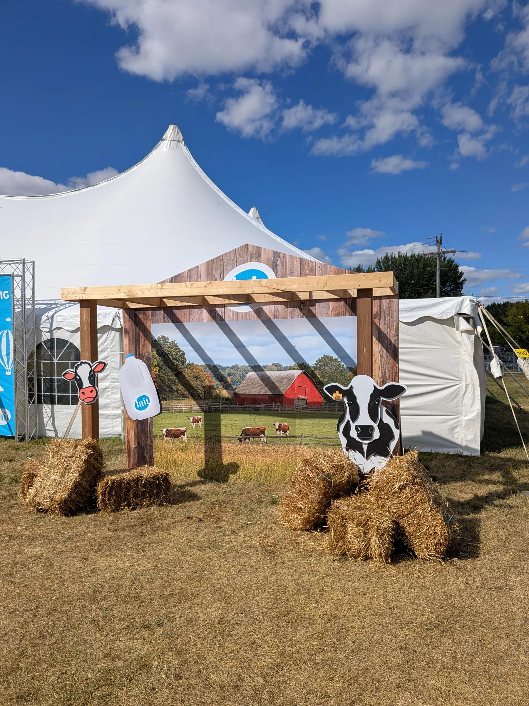 Décor de façade en bois avec visuel champêtre et bottes de foin, sous un chapiteau