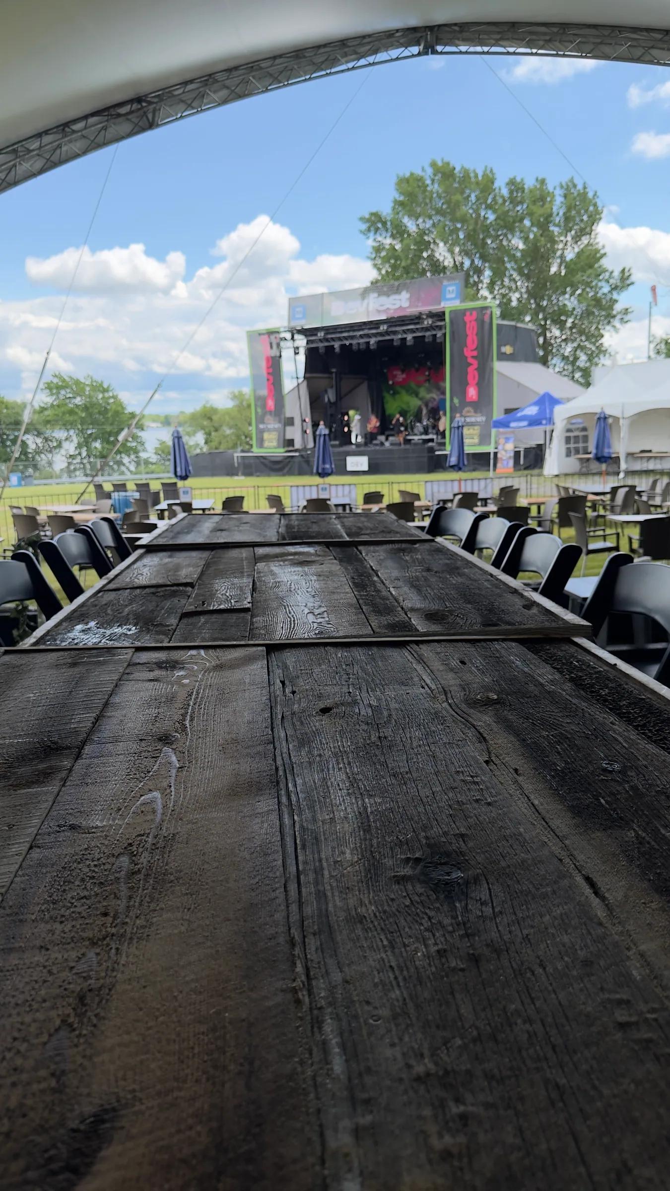 Longue table en bois foncé et chaises pliantes noires devant la scène, DevFest