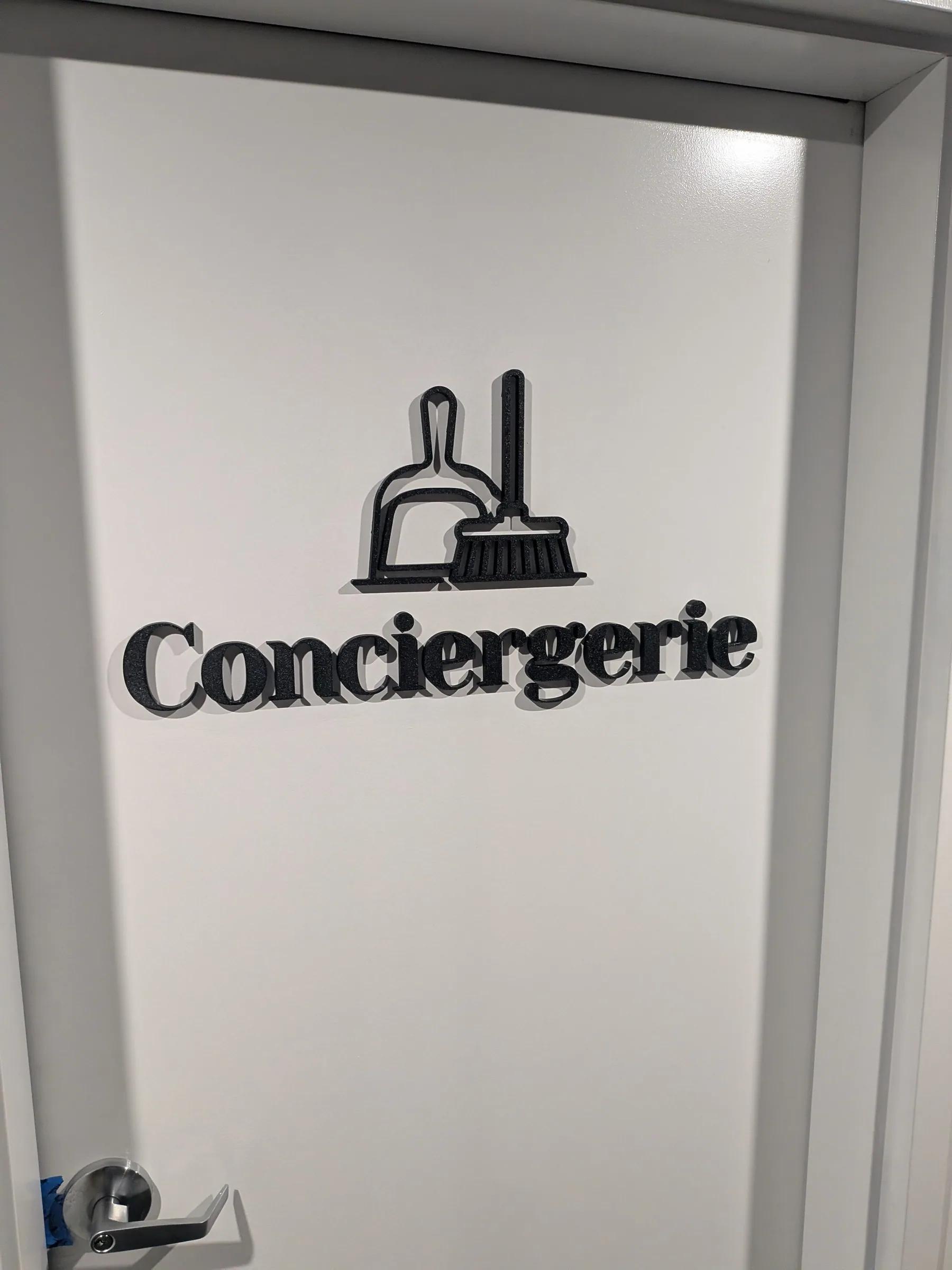 Pictogramme et lettrage 3D « Conciergerie » sur un mur blanc