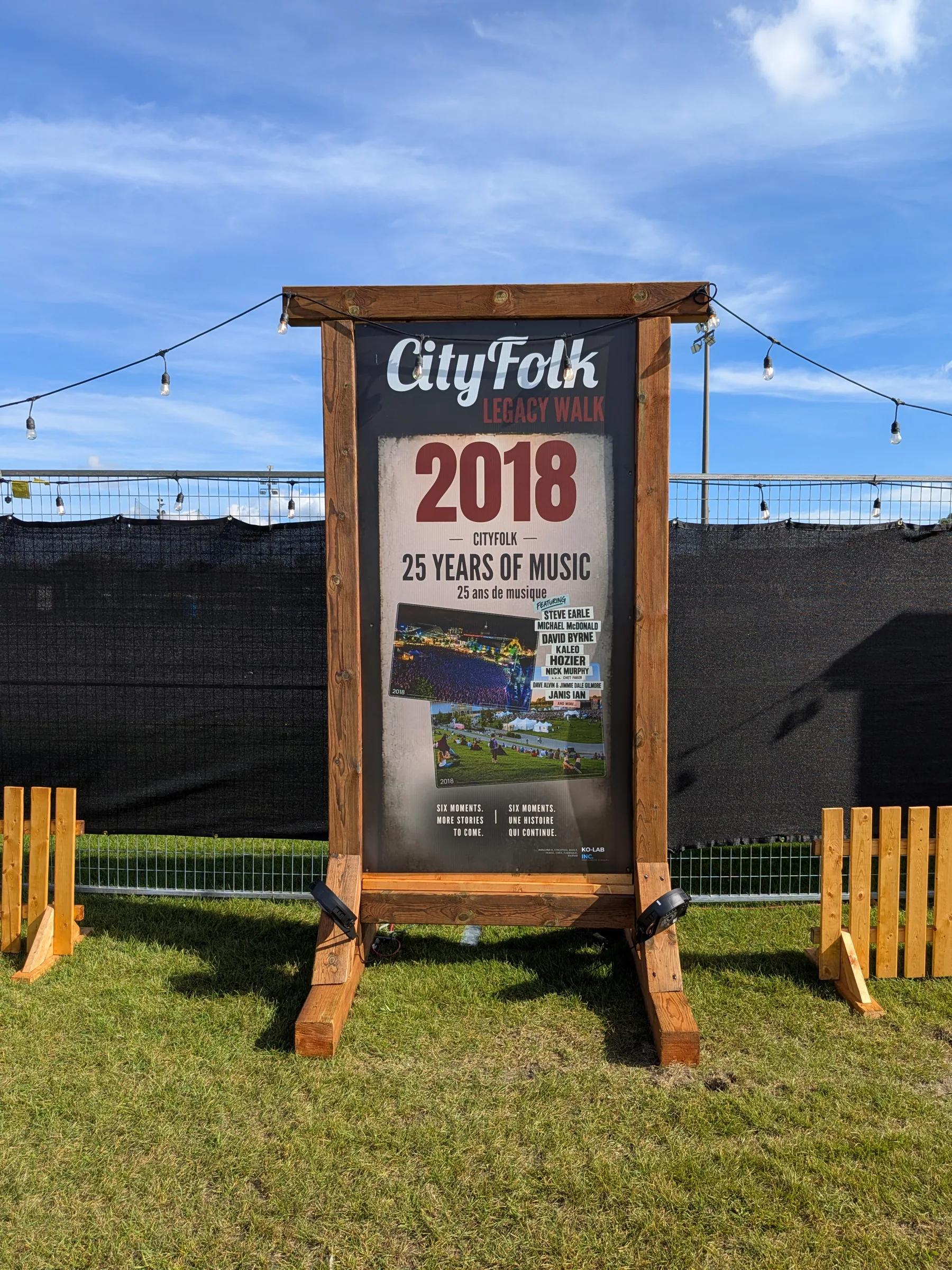Alignement des structures de bois du Legacy Walk sur la pelouse du festival