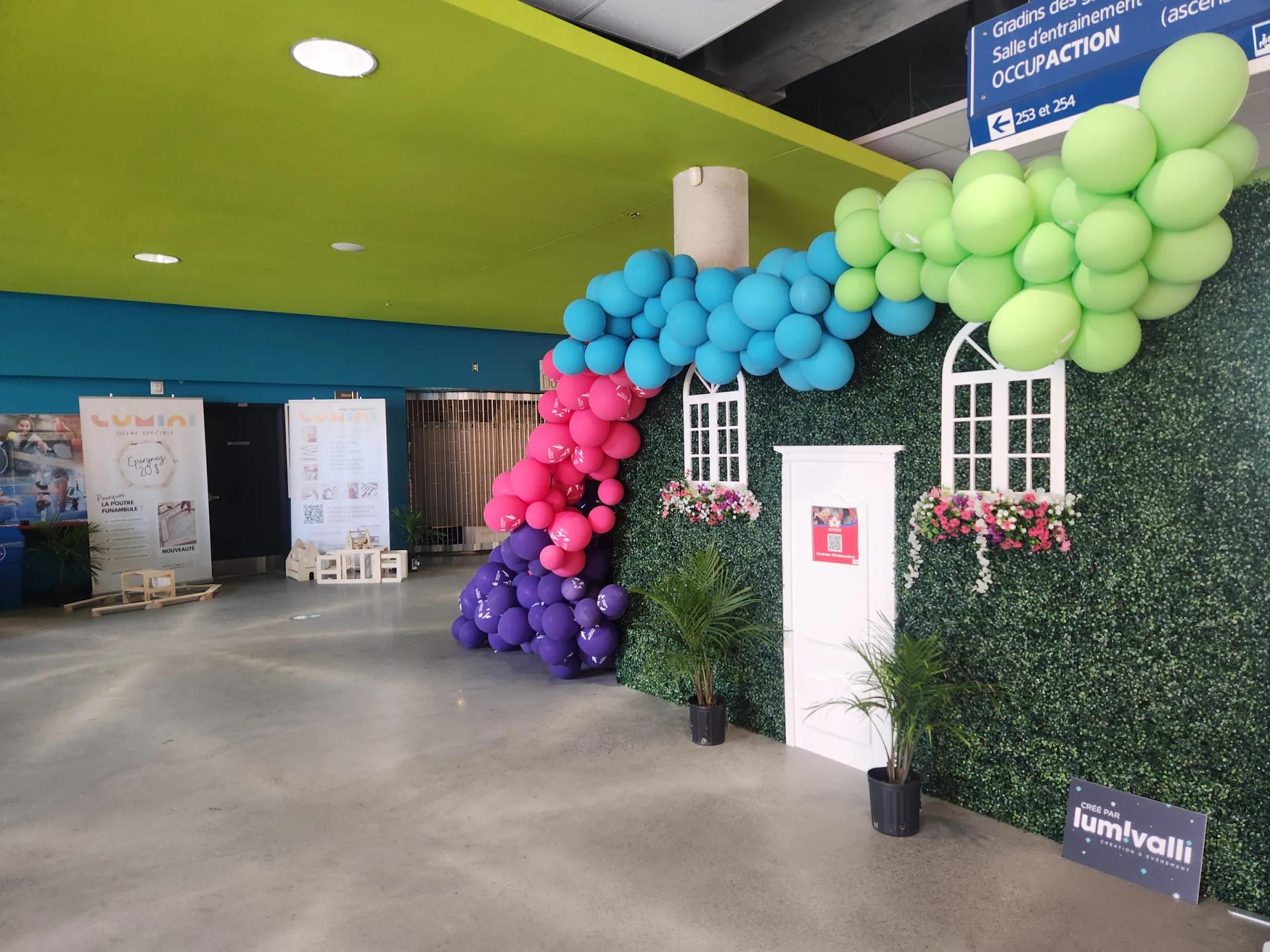 Décor de façade avec fenêtres, plantes et arche de ballons, vue rapprochée