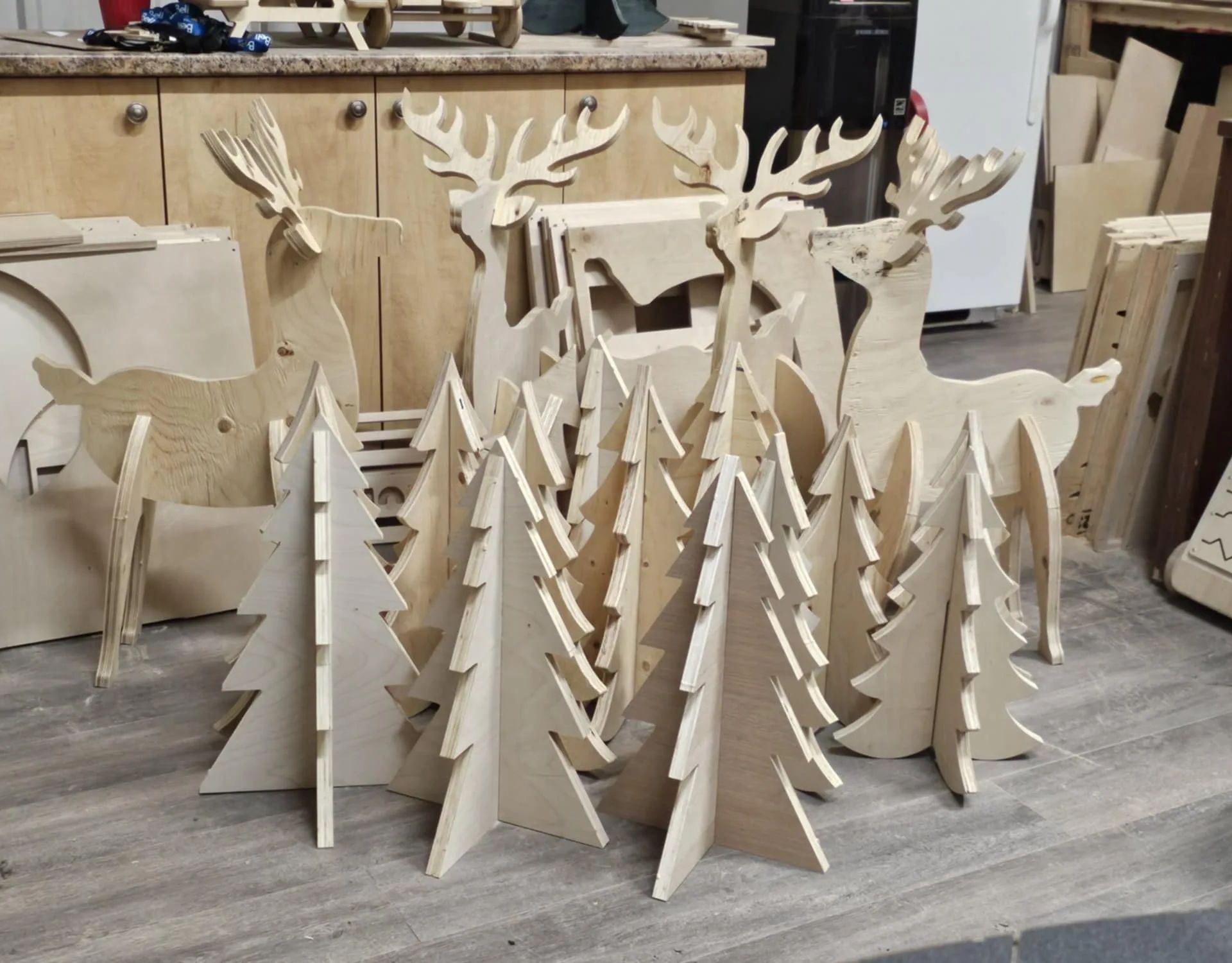 Série de rennes et de sapins en bois découpés sur un établi