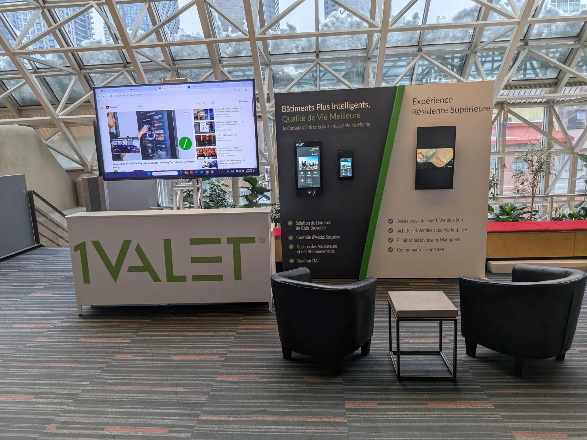 Kiosque 1Valet dans un hall vitré : comptoir, écran et fauteuils
