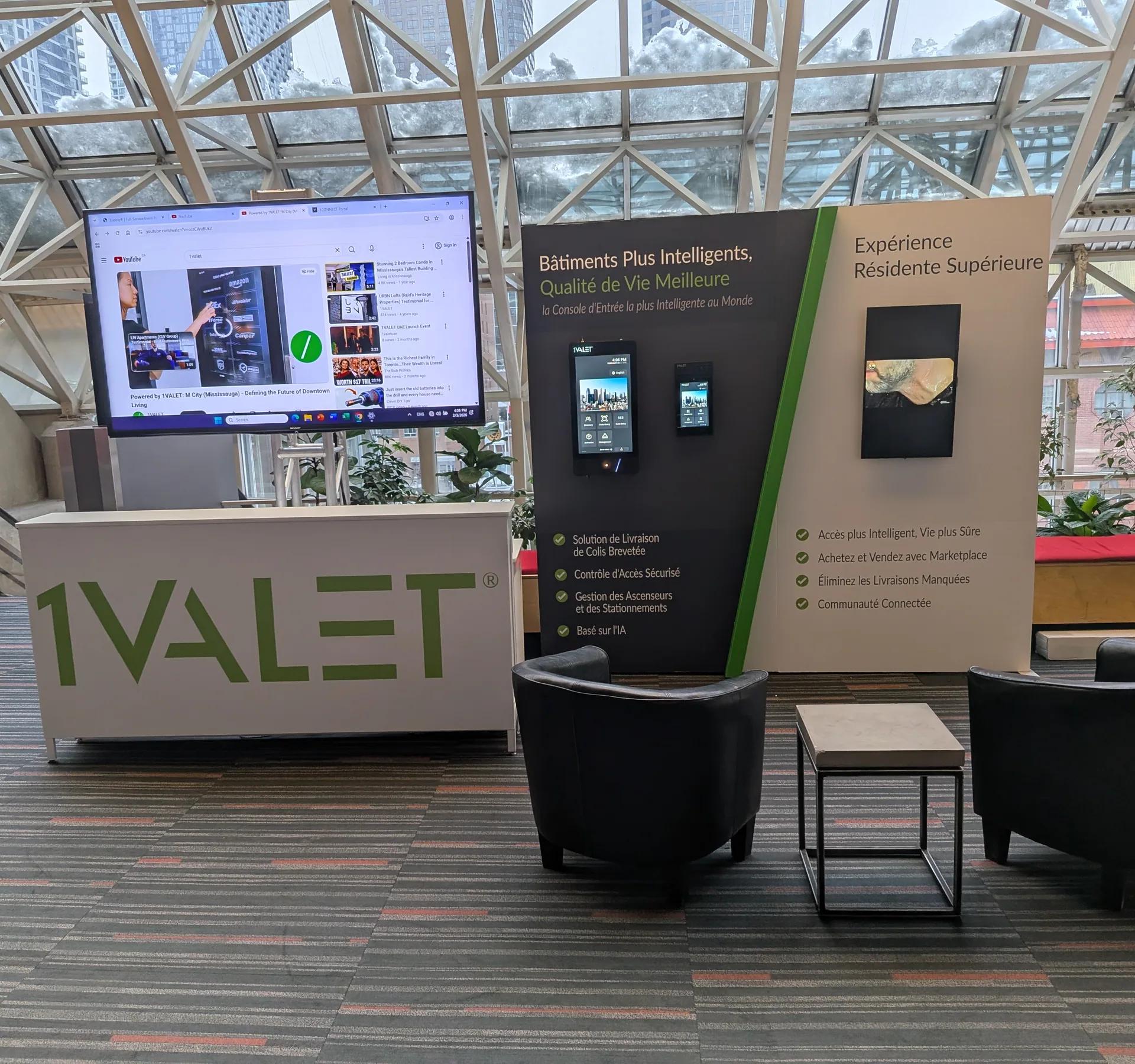 Kiosque 1Valet dans un hall vitré : comptoir, écran et fauteuils