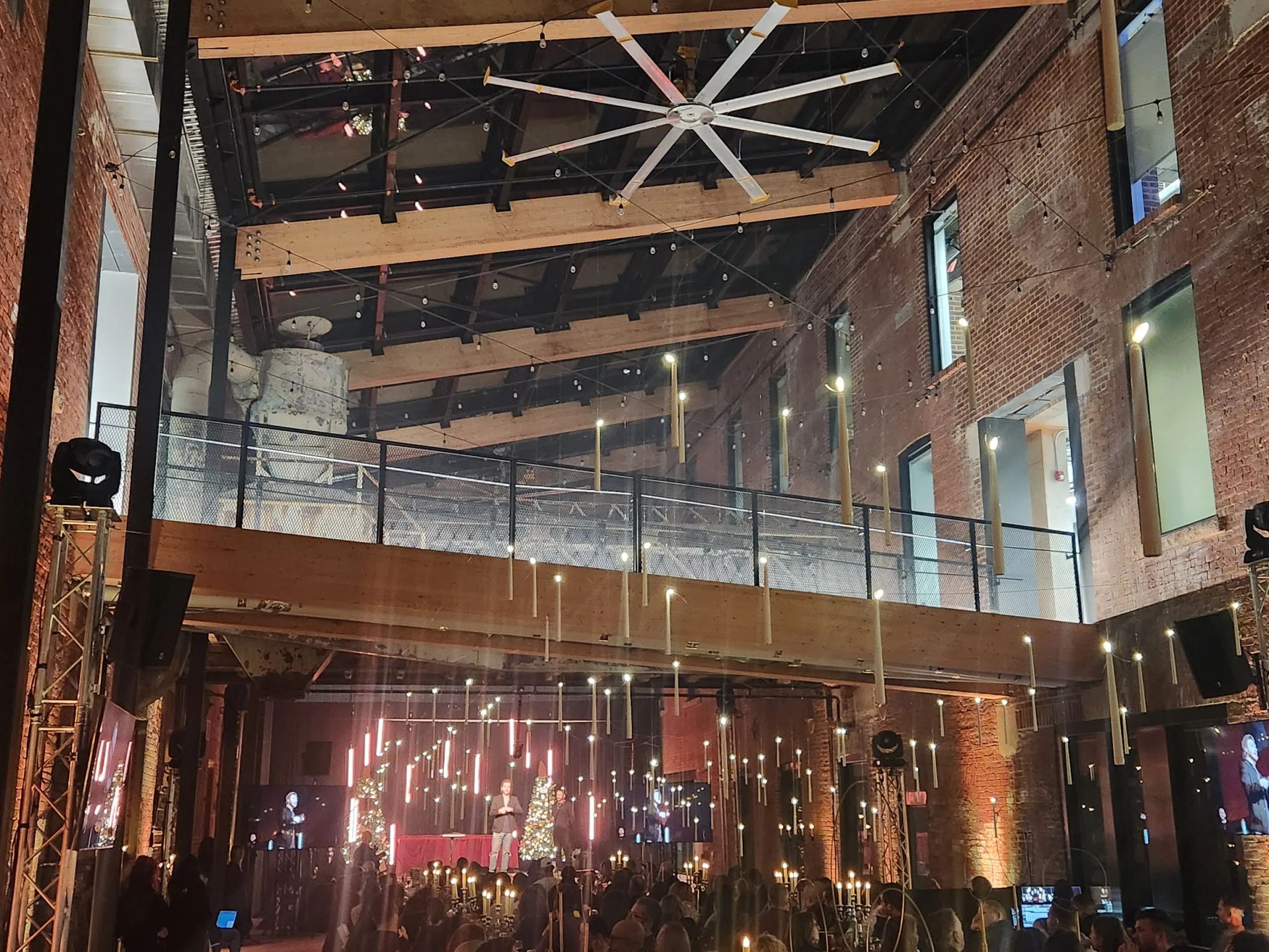 Salle industrielle en brique éclairée pour une soirée, guirlandes et lumières colorées