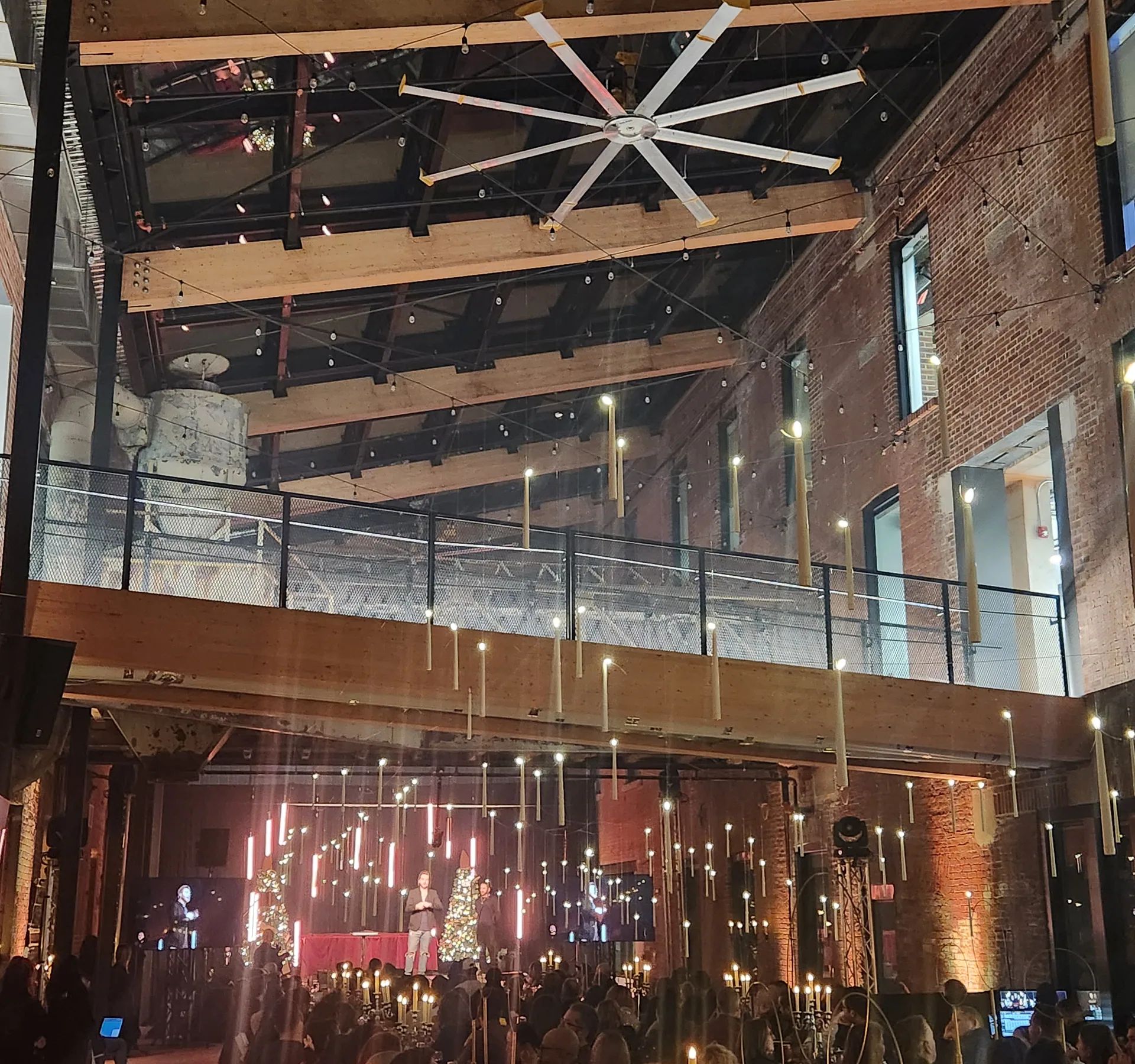 Salle industrielle en brique éclairée pour une soirée, guirlandes et lumières colorées